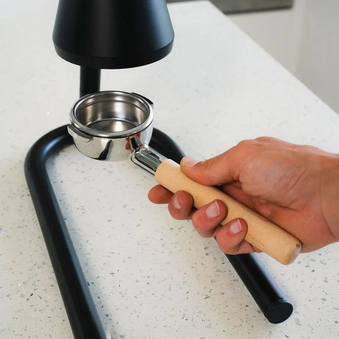 Hand holding a wooden handle 58mm portafilter