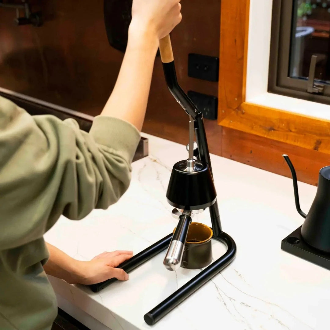 Home barista pulling an espresso shot on a lever espresso machine.