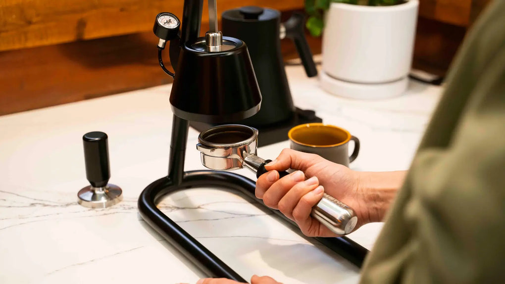 Home barista attaching coffee handle to lever espresso machine.